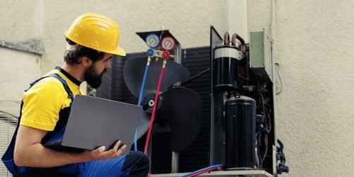 Technician looking for refrigerant leaks